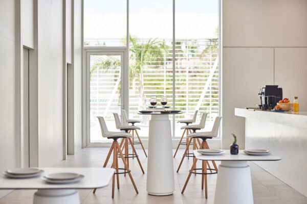 Dorik Cafe Table in a modern café and collaborative workspace with round tabletop and pedestal base